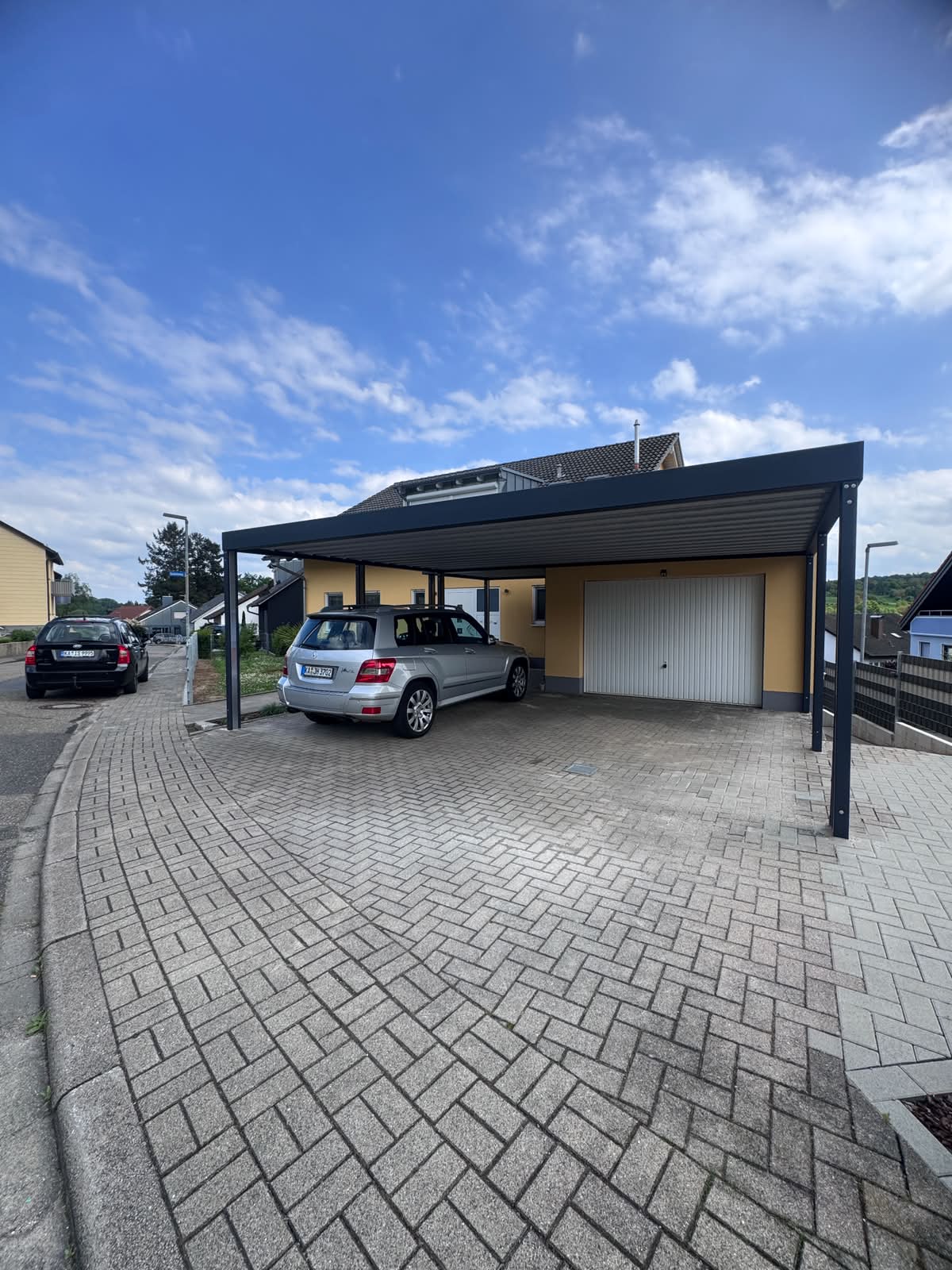 Fertiger Flachdach-Carport in Anthrazit mit Fahrzeug in Kraichtal